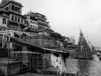 Boats moored in city against sky