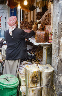 Rear view of a man for sale at market stall