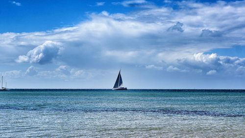 Sailboat sailing on sea against sky