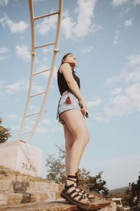 Low angle view of woman standing against sky