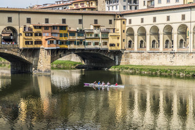 Bridge over river by buildings in city