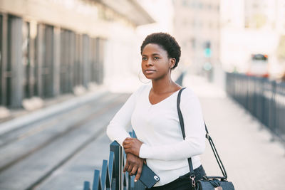 Portrait of smiling young woman standing in city