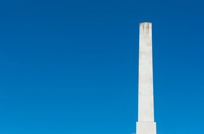 Low angle view of obelisk against clear blue sky