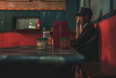 Side view of young woman sitting in restaurant