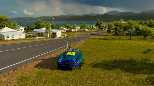 Car on road by land against sky