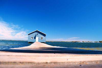 Lifeguard hut on beach against blue sky