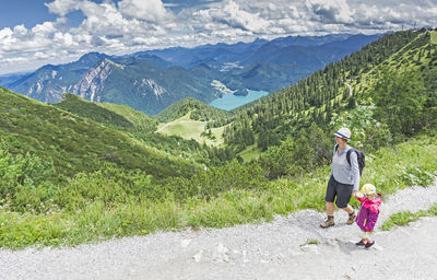 Mother with daughter on mountain against sky