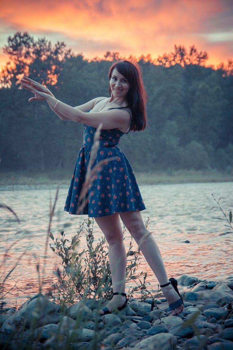 person, young adult, lifestyles, young women, full length, casual clothing, leisure activity, looking at camera, portrait, standing, front view, three quarter length, happiness, smiling, arms outstretched, sky, water