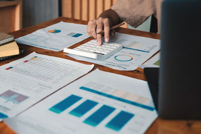 Midsection of business colleagues working on table