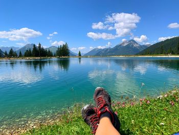 Midsection of woman in lake against sky
