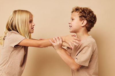 Sibling fighting against colored background