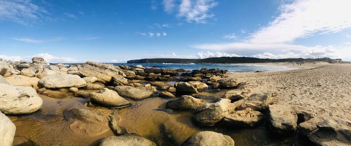 Panoramic view of rocks on beach against sky