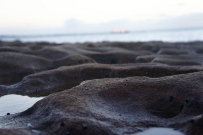 Close-up of sand on beach against sky