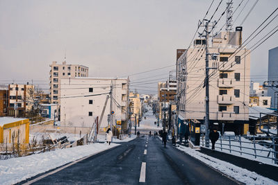 Street amidst buildings in city during winter