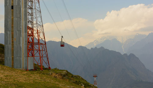 Low angle view of overhead cable car against sky