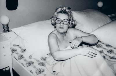 Portrait of shirtless man lying down on bed