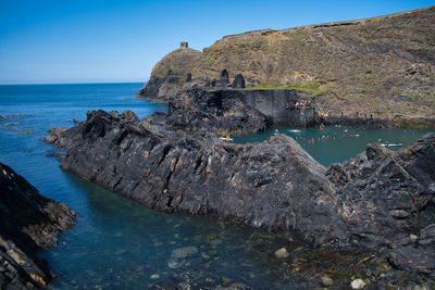Rock formation on sea shore against sky
