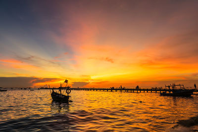 Silhouette boat in sea against sky during sunset