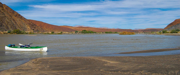 Boat moored on shore against sky