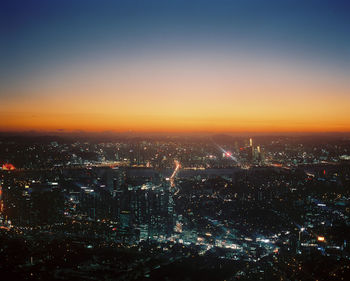 High angle view of illuminated cityscape against sky at night