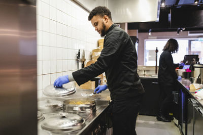 Male chef preparing dumplings in kitchen at restaurant