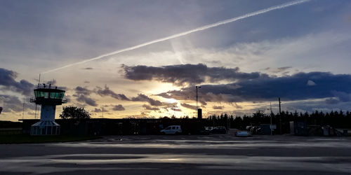 Road by building against sky during sunset