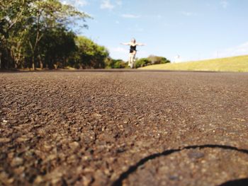 Defocused image of woman riding bicycle on road against sky