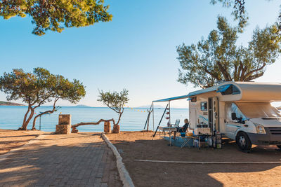 Family traveling with motorhome are eating breakfast on a beach. tcrete, greece.