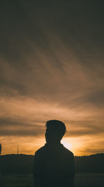 Silhouette man standing against sky during sunset