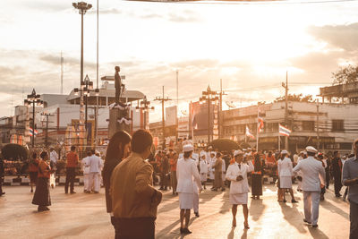Rear view of people walking on street in city