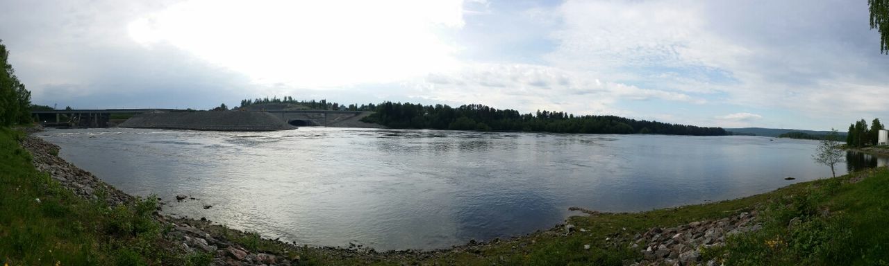 water, sky, tranquil scene, tranquility, scenics, cloud - sky, beauty in nature, lake, nature, grass, cloud, reflection, mountain, idyllic, cloudy, non-urban scene, river, tree, panoramic, landscape