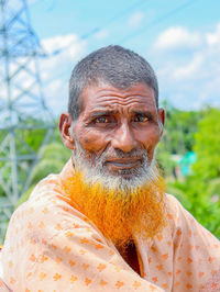 Portrait of young man standing against sky