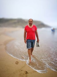 Portrait of young man standing on beach