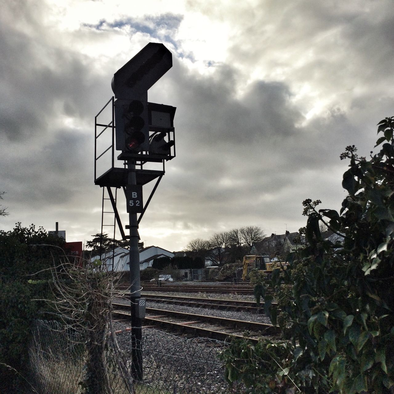 sky, cloud - sky, cloudy, built structure, tree, architecture, cloud, building exterior, low angle view, overcast, weather, outdoors, connection, metal, railroad track, day, nature, no people, dusk, technology