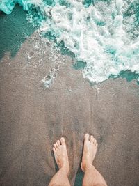 Low section of man standing at shore