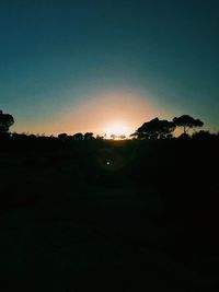 Silhouette landscape against clear sky during sunset