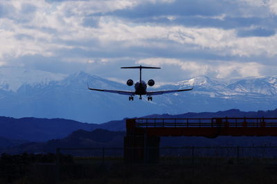 Airplane flying against cloudy sky