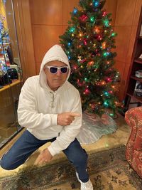 Full length of man wearing sunglasses on christmas tree