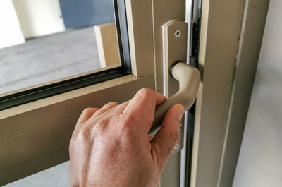 Close-up of person hand with open door