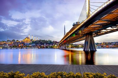 Bridge over river against cloudy sky