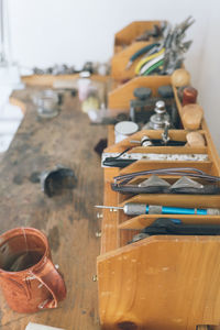 Detail of assorted tools used for making jewelery on wooden work bench