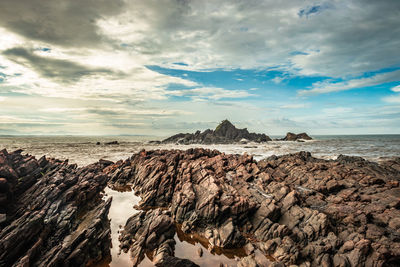 Rocky sea beach with crashing waves at morning from flat angle