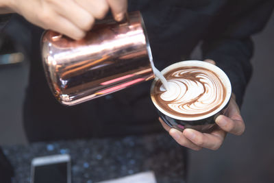 Cropped image of hand holding coffee cup