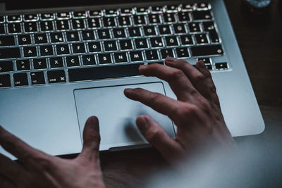 Close-up of person using laptop on table