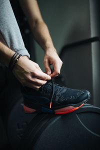 Close-up athlete tying his shoe in gym.