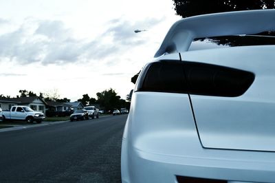 Cars on road against cloudy sky