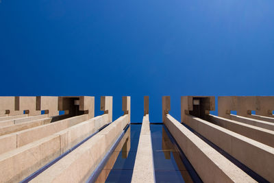 Empty chairs against clear blue sky on sunny day