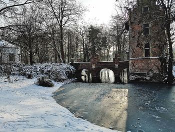 Arch bridge over canal against sky during winter