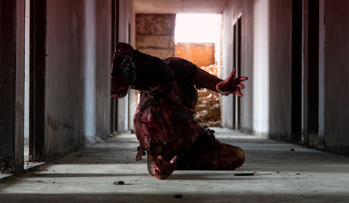 Man wearing spooky halloween costume lying on floor