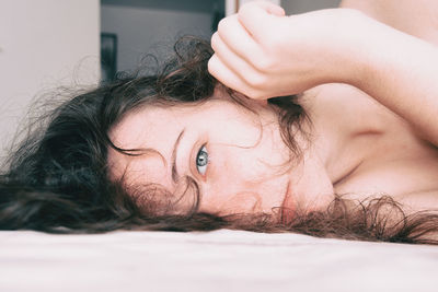 Close-up of woman lying on bed at home